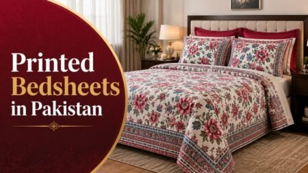 A cream-colored bedsheet set featuring a vibrant floral print with large pink and red blossoms, matching pillow shams, and deep red accent pillows.